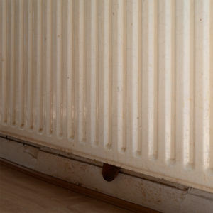 image of the kitchen radiator that has a lifetime supply of socks behind it and a wooden spoon, part of Covid chronicles